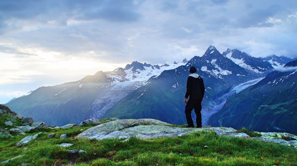 Man standing atop mountain (Nicolas Cool, Unsplash)