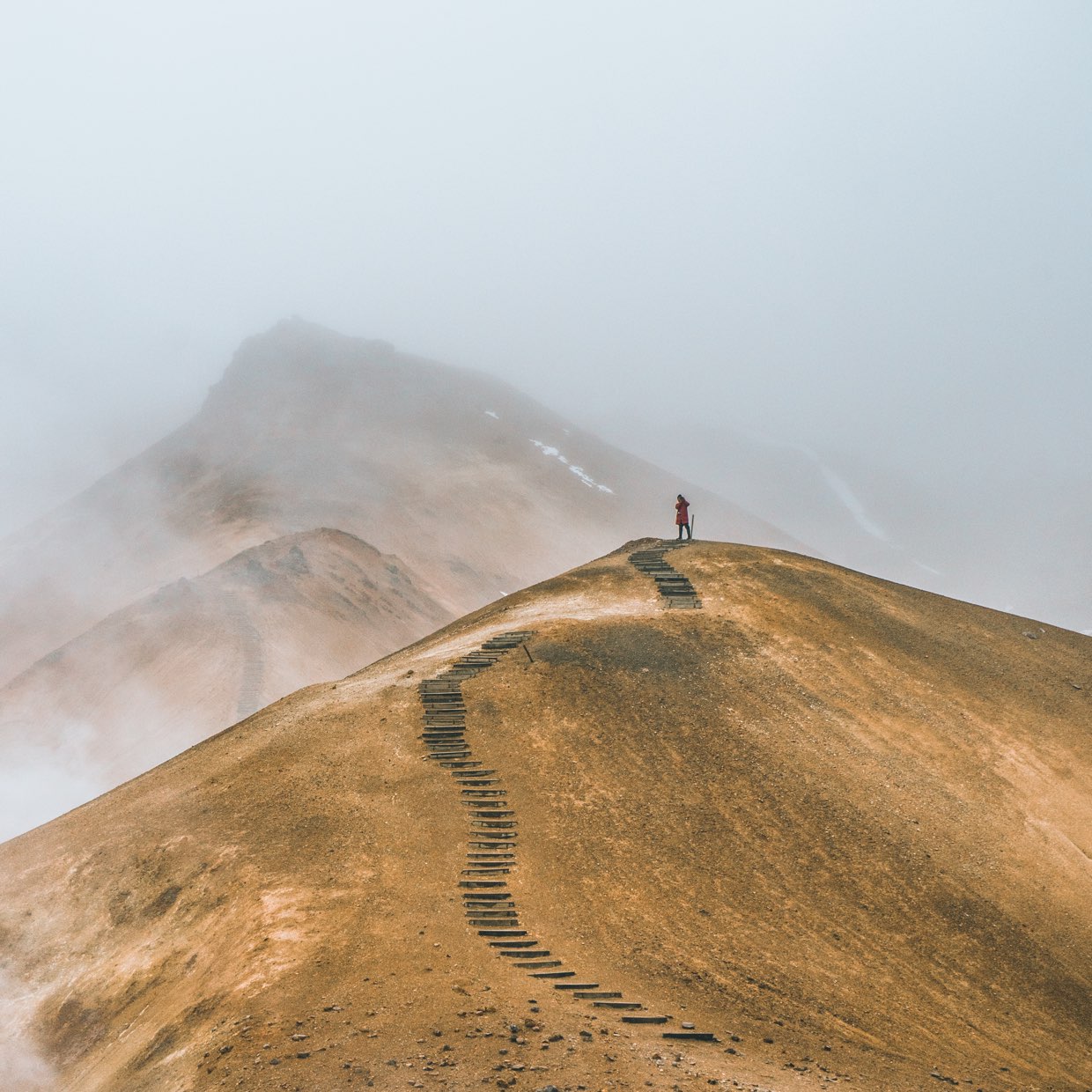 Person at top of a small hill and faded steps (Alexander Milo, Unsplash)
